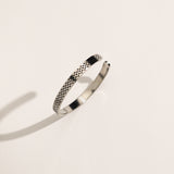 A silver-colored cuff bracelet with a geometric palestine kuffiyeh pattern, displayed on a white background.